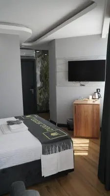 a bedroom with a bed and a tv on a wall at Dual Hotel Halkalı in Istanbul