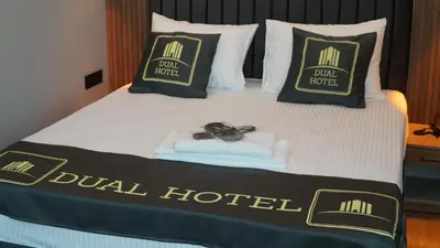 a hotel room with a bed with a robe and shoes on it at Dual Hotel Halkalı in Istanbul