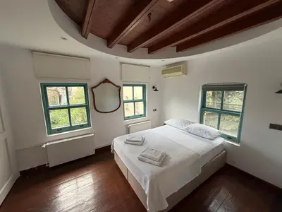 a bedroom with a white bed and two windows at Galata Tower Suites in Istanbul