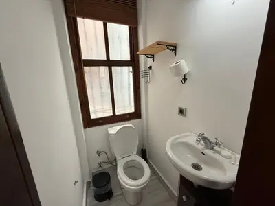 a bathroom with a toilet and a sink and a window at Galata Tower Suites in Istanbul