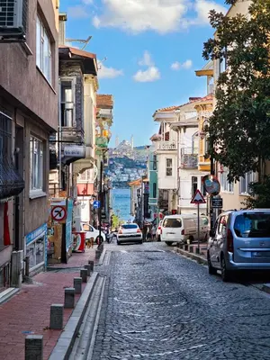 a cobblestone street in a city with cars parked at Equipped Flat w Balcony - In The Arnavutköy - Bebek in Istanbul