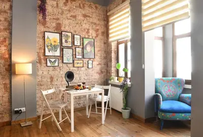 a living room with a table and chairs and a brick wall at Historical Wooden Style AC in Beyoğlu Galata in Istanbul