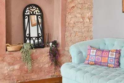 a blue couch in a living room with a mirror at Historical Wooden Style AC in Beyoğlu Galata in Istanbul