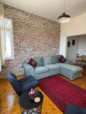 a living room with a couch and a brick wall at The Kinyas House - Apartment in Kadıköy Historical Fishermen's Market in Istanbul