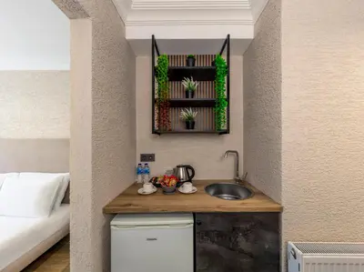a kitchen with a sink in a room with a bed at Çorlu Temel Hotel in Corlu