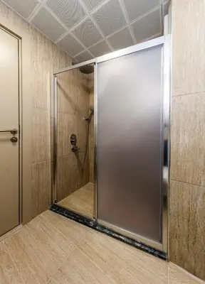 a shower stall with a metal door in a room at Çorlu Temel Hotel in Corlu