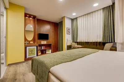 a bedroom with a large bed and a tv at Sometimes Hotel Taksim in Istanbul