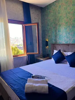 a bedroom with a bed with two towels on it at GÜNEŞLİ SUİT OTEl in Istanbul