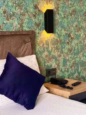 a bedroom with a bed with a phone on a table at GÜNEŞLİ SUİT OTEl in Istanbul