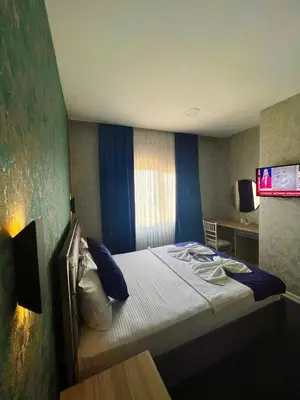 a small bedroom with a bed with blue walls at GÜNEŞLİ SUİT OTEl in Istanbul