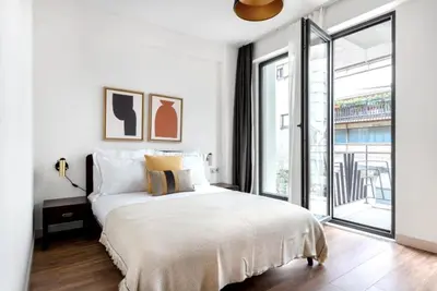 a white bedroom with a bed and a large window at Elegant & Charming Apartment in Beyoglu in Istanbul