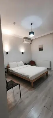 a bedroom with a large bed and a chair at Şişli Suites - Room22 in Istanbul
