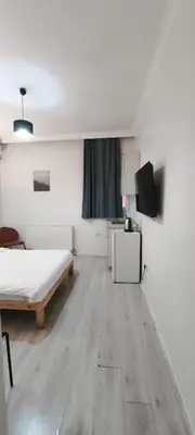 a white room with a bed and a television at Şişli Suites - Room22 in Istanbul