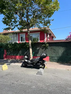a motorcycle parked on the street in front of a house at Şişli Suites - Room22 in Istanbul