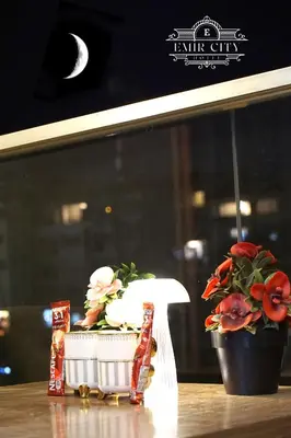 a table with a potted plant and two packets of food at Emir City Hotel in Bursa