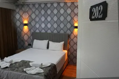 a bedroom with a bed and a sign on the wall at Emir City Hotel in Bursa