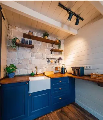 a kitchen with blue cabinets and a brick wall at Boheme Bungalow Sapanca in Sapanca