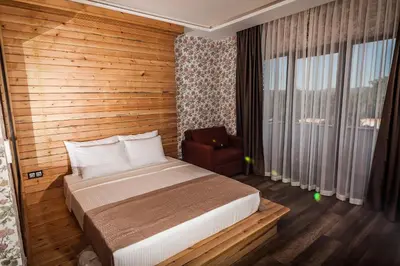 a bedroom with a bed and a chair and a window at My Green Otel in Sapanca
