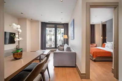 a living room with a dining table and a bedroom at Sentire Hotels & Residences Taksim in Istanbul