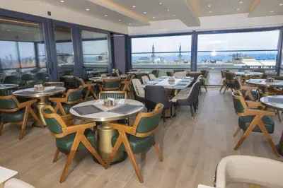 a restaurant with tables and chairs and large windows at Lions Royal Hotel in Istanbul