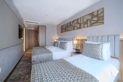 a hotel room with two beds and a tv at Lions Royal Hotel in Istanbul