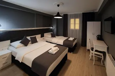 a hotel room with two beds and a desk at Utarit Hotel in Istanbul