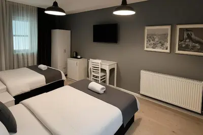 a bedroom with two beds and a desk and a television at Utarit Hotel in Istanbul
