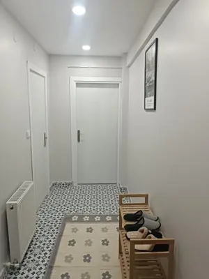 a hallway with white walls and a floor with shoes at Üsküdar'da Tam Size Göre S in Istanbul