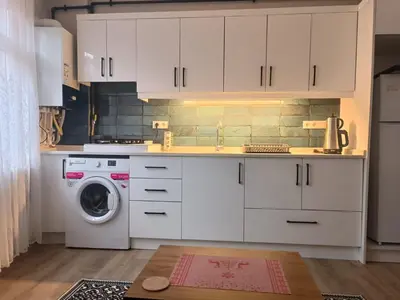 a kitchen with white cabinets and a washing machine at Üsküdar'da Tam Size Göre S in Istanbul