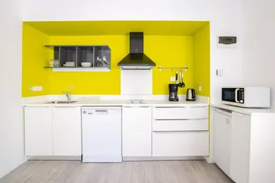 a kitchen with white cabinets and a yellow wall at Cute Compact 1Bd1Bath Gem Shared Terrace! #397 in Istanbul