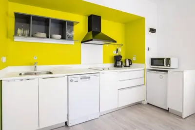 a kitchen with white cabinets and a yellow wall at Cute Compact 1Bd1Bath Gem Shared Terrace! #397 in Istanbul