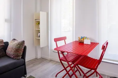 a red table and chairs in a room with a couch at Cute Compact 1Bd1Bath Gem Shared Terrace! #397 in Istanbul
