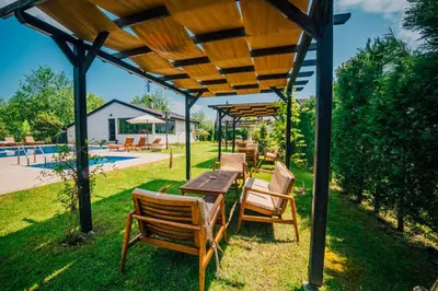 a group of chairs and tables under a wooden pergola at Sapanca Cayir Cimen Otel in Sapanca