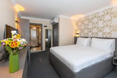 a hotel room with a bed and a vase of flowers at Mays Otel in Istanbul
