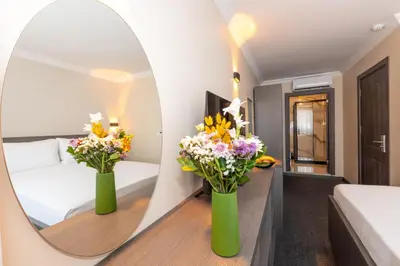 a room with two vases with flowers in a mirror at Mays Otel in Istanbul