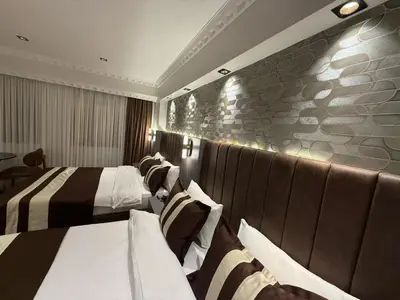a hotel room with two beds and a stone wall at Blue Istanbul Hotel Taksim in Istanbul