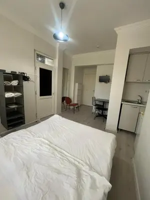 a bedroom with a white bed and a kitchen at Şişli Suites - Room25 in Istanbul