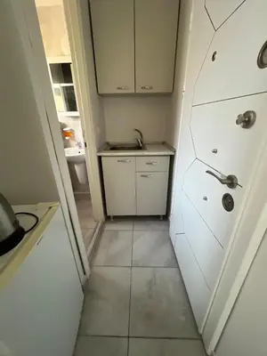 a small kitchen with a sink and white cabinets at Şişli Suites - Room32 in Istanbul