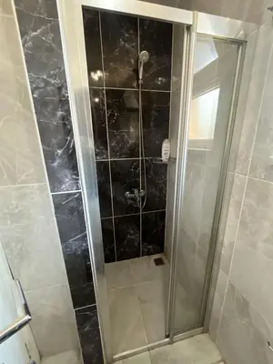 a shower with a glass door in a bathroom at Şişli Suites - Room32 in Istanbul
