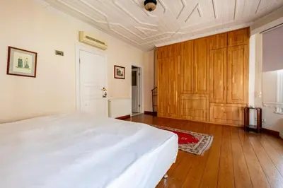 a bedroom with a white bed and a wooden door at House with Terrace in Sultanahmet in Istanbul
