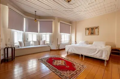 a bedroom with a bed and two windows and a rug at House with Terrace in Sultanahmet in Istanbul