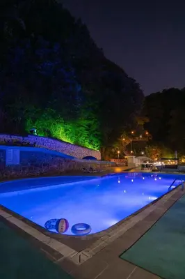 a large blue swimming pool at night at CANPOLAT Sapanca Hotel in Sapanca