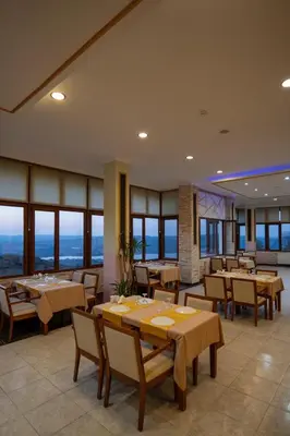 a dining room with tables and chairs and windows at CANPOLAT Sapanca Hotel in Sapanca