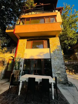a building with a table and chairs in front of it at CANPOLAT Sapanca Hotel in Sapanca