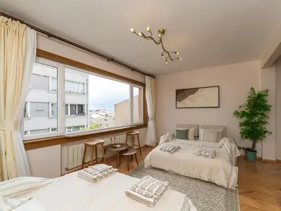 a bedroom with two beds and a large window at sevim suites Nişantaşı Rumeli in Istanbul