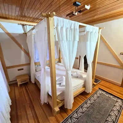 a bedroom with a bed with white drapes at Uludag Nefes Echoes by the Woods in Uludag