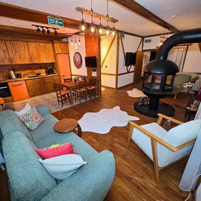 a living room with a blue couch and a wood stove at Uludag Zirve Garden - BBQ Jacuzzi
