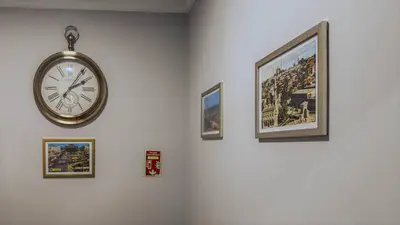 a clock hanging on a wall with pictures at Balat Side Apart in Istanbul