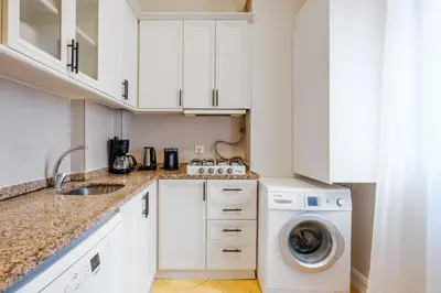 a kitchen with white cabinets and a washer and dryer at Urban Balcony Suite - Close to Taksim in Istanbul