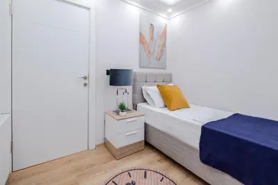 a small bedroom with a bed with a blue blanket at Newly Built in Sisli • Fast WiFi • Elevator in Istanbul
